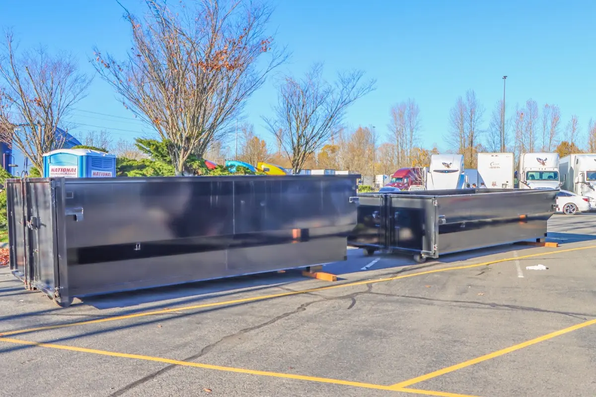 Professional dumpster rental service with roll-off container on residential driveway in Sutton